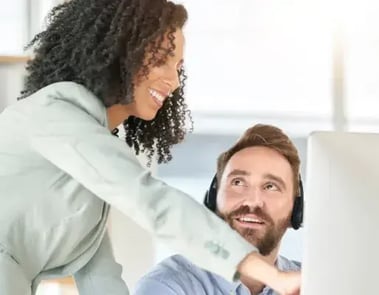 Man and woman interacting with a desktop computer.